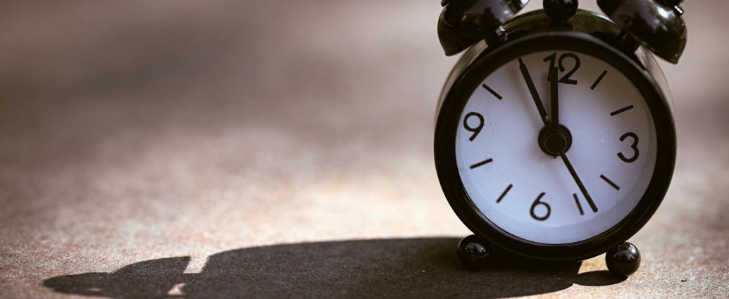 vintage alarm clock casting long shadow