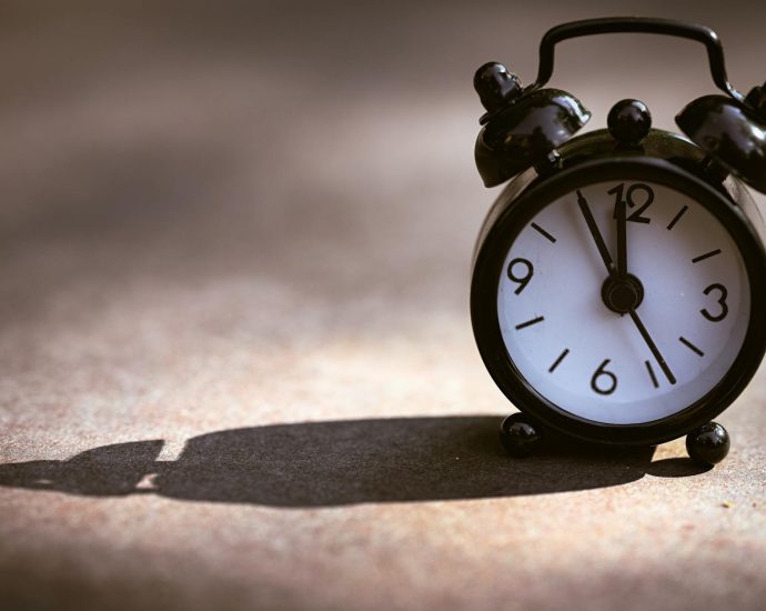 vintage alarm clock casting long shadow