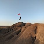 person with flag of indonesia jumping on barren rocks