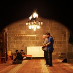 men praying inside a dimly lit mosque
