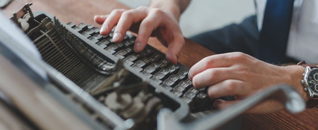 person typing on typewriter