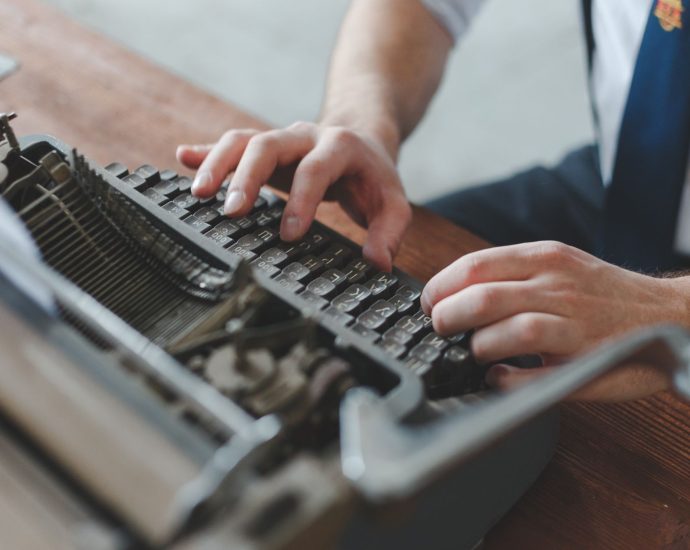 person typing on typewriter