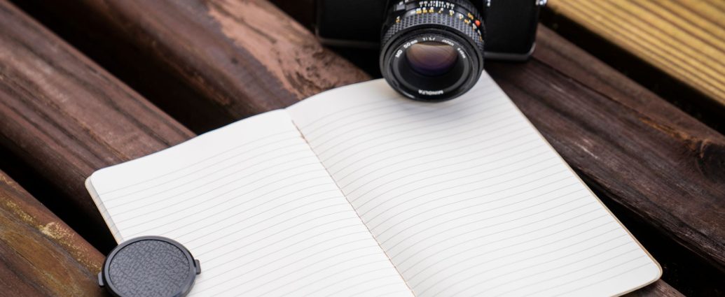 minolta camera beside a notebook