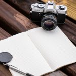 minolta camera beside a notebook