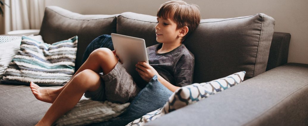 boy sitting with tablet on couch