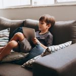 boy sitting with tablet on couch