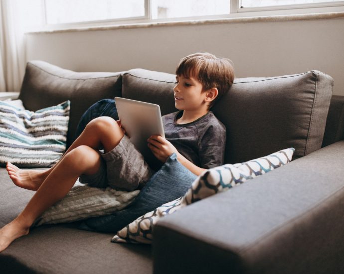 boy sitting with tablet on couch
