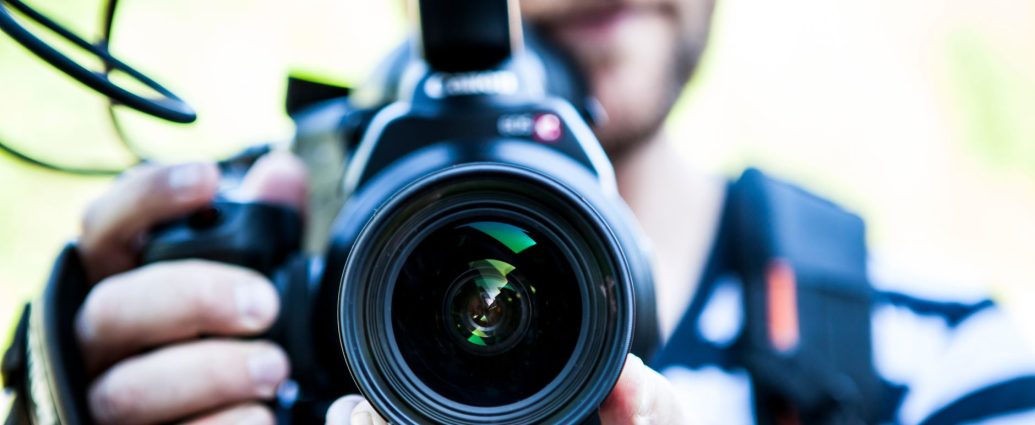 person holding canon dslr camera close up photo