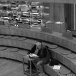 senior adult reading in modern library setting