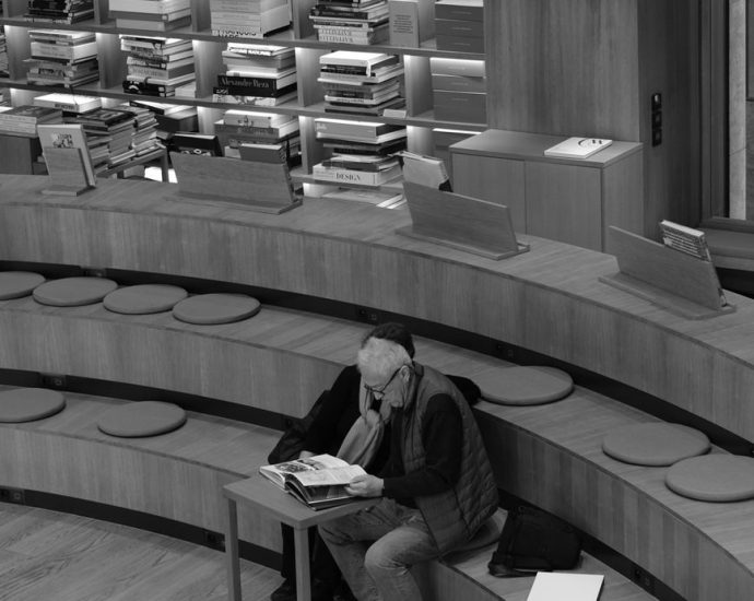 senior adult reading in modern library setting