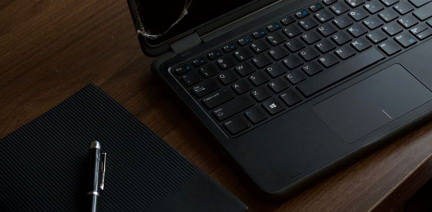 dark office workspace with laptop and notebook