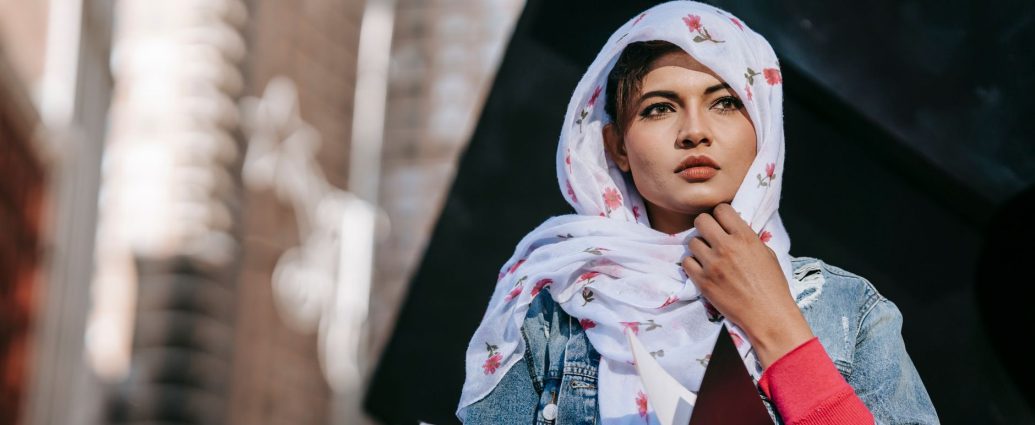 serious young woman in headscarf holding papers in folder
