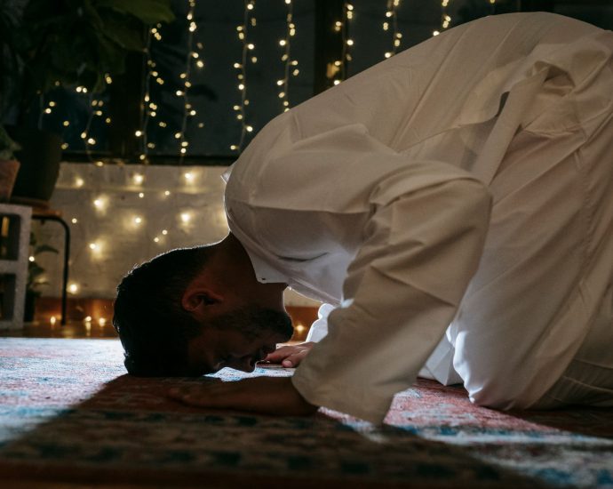man in white thobe praying