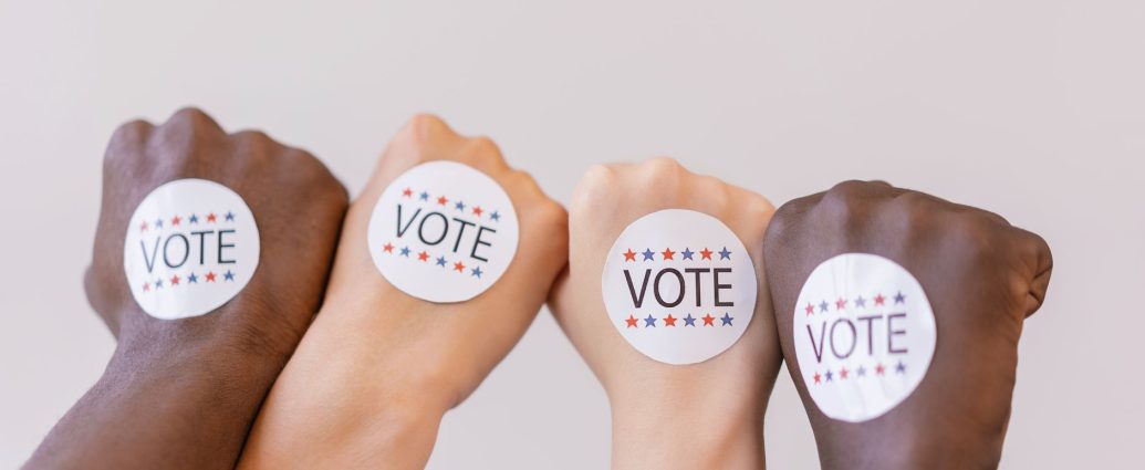 close up photo of vote stickers on people s fist